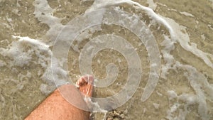 Close up leg of man walking in the sea, splash around. SUPER SLOW MOTION