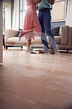 Close Up On Legs As Romantic Senior Retired Couple Dancing In Lounge At Home Together