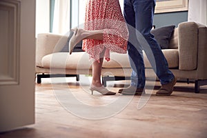 Close Up On Legs As Romantic Senior Retired Couple Dancing In Lounge At Home Together