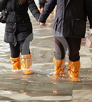 Close Up of legs with boots due to the high water in Venice.