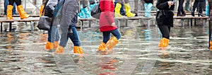 Close Up of legs with boots due to the high water in Venice.