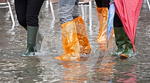 Close Up of legs with boots due to the high water in Venice.