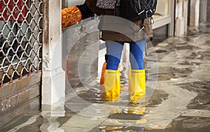 Close Up of legs with boots due to the high water in Venice.