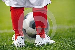 Close up on legs of children soccer player. Young boy kid practice football on grass field