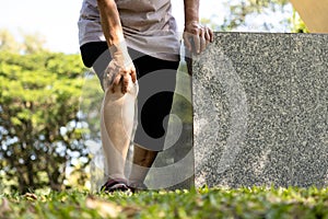 Close-up of legs of injured senior woman have knee pain,swollen knees and hand to massage the knee while walking,old people suffer