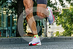 close-up legs male runner running city marathon race
