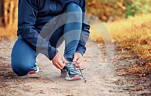 Close up a legs of runner in a black sports leggins and sneakers