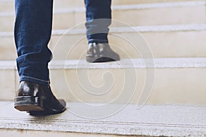 Close up legs shoes of young business man One person walking stepping going up the stairs