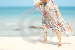 Close up legs smiling  lifestyle woman wearing fashion  dress summer running on the sandy ocean beach. Happy woman enjoy and relax