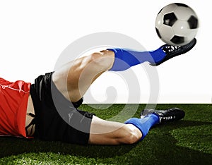 Close up legs and soccer shoe of football player in action doing tackle and kicking ball