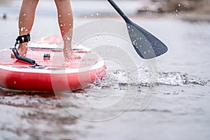 Close-up of legs Stand up paddle boarding on the river