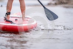 Close-up of legs Stand up paddle boarding on the river photo