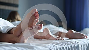 Close-up of the legs of two small children sleeping on a large bed in a cozy and bright hotel room. Relaxation and rest