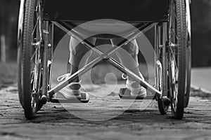 Close-up of legs in a wheelchair. The girl is disabled. The concept of a wheelchair, disabled person, full life, paralyzed,