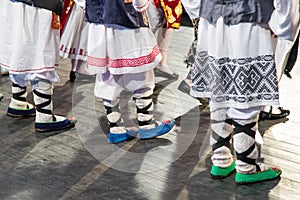 Close up of legs of young Romanian dancers perform a folk dance in traditional folkloric costume. Folklore of Romania