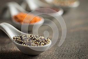 Close up of lentils and quinoa in white spoons on wood