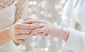 Close up of lesbian couple hands with wedding ring