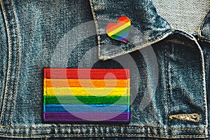 Close-up of LGTBI flag textile patch on a denim jacket and LGTBI pin heart shaped