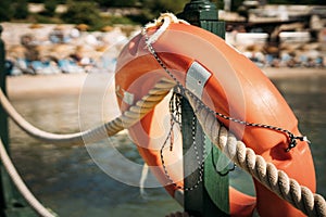 Close-up of a life buoy hanging on a fence near the sea on the beach