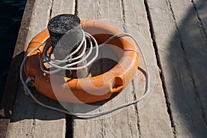 Close up of lifebuoy. Rescue equipment for emergency on water. Lifebuoy and mooring cannon on dock