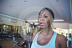 Close up lifestyle indoors portrait of young attractive and sweaty black afro American woman training hard at fitness club walking