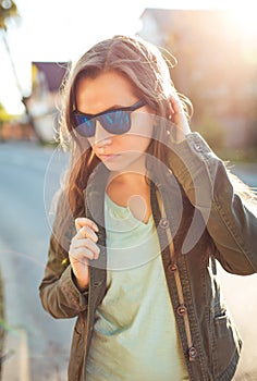 Close up lifestyle portrait of pretty young fashion brunette in