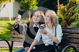 Close up lifestyle selfie portrait of two young positive woman having fun and making selfie, teenage hipster trendy clothes, long