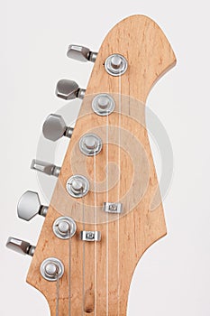 Close up of lightweight chrome tuning machines on neck of electric guitar, studio shoot