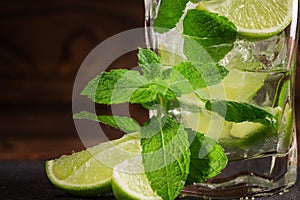 A close-up of a lime mojito. A refreshing green mojito with liquor, mint and ice. An alcoholic beverage on a wooden background.