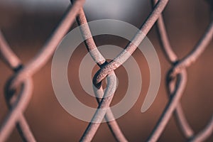 A close up of the links of a chain link fence using selective focus