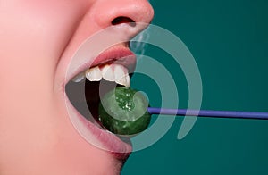 Close up lips with lollipop isolated, sexy blowjob, sensual mouth with lipstick eats sweets. Sexy design for women and