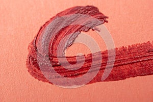 close up of a lipstick smudged on a red background