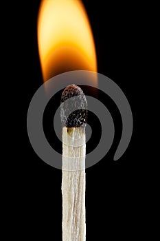 Close-up lit match with flame on black background