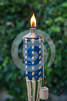Close up of lit Tiki torch before a backyard party.