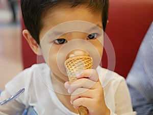 Little Asian baby girl enjoy eating ice cream cone