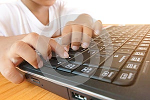 Close up little asian boy using laptop pc for technology learning, education and playing online games at home. E-learning technolo