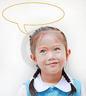 Close up little Asian girl in school uniform looking up and speak bubble thinking something. Imagination concept