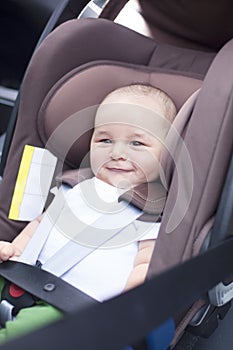 Close up of little baby boy in a car in a child seat