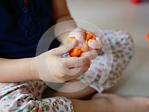 Close up of little baby`s hands squeezing playdough