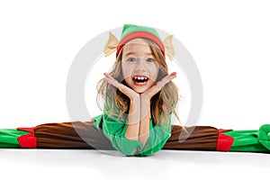 Close-up little beautiful girl dressed like funny gnome or elf sitting in twine isolated over white background. Winter