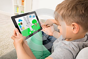 Boy Playing Game On Digital Tablet