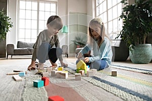 Close up little girl and boy playing with wooden blocks