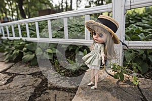 Close-up of a little girl doll lying on the stone steps of the park