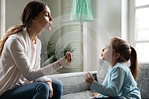 Close up little girl involved in lesson with speech therapist