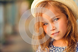 Close up little girl on porch of old ruined house.