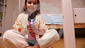 close-up of a little girl with a red power electric screwdriver turned on