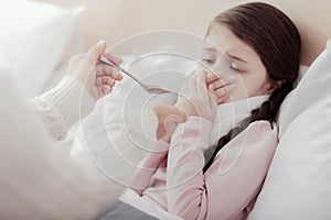 Close up of little girl resisting taking mixture