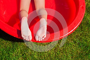 Close-up of a little girl's legs in the pool