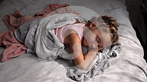 Close up of little girl sleeping in bed in light room. Preschool girl getting out of bed. Good morning calm awakening 4k