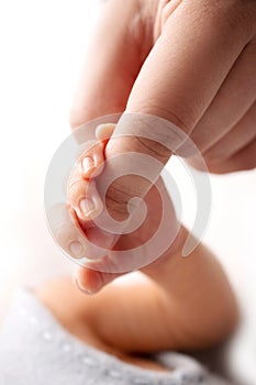Close-up little hand of child and palm of mother and father. The newborn baby has a firm grip on the parent& x27;s finger